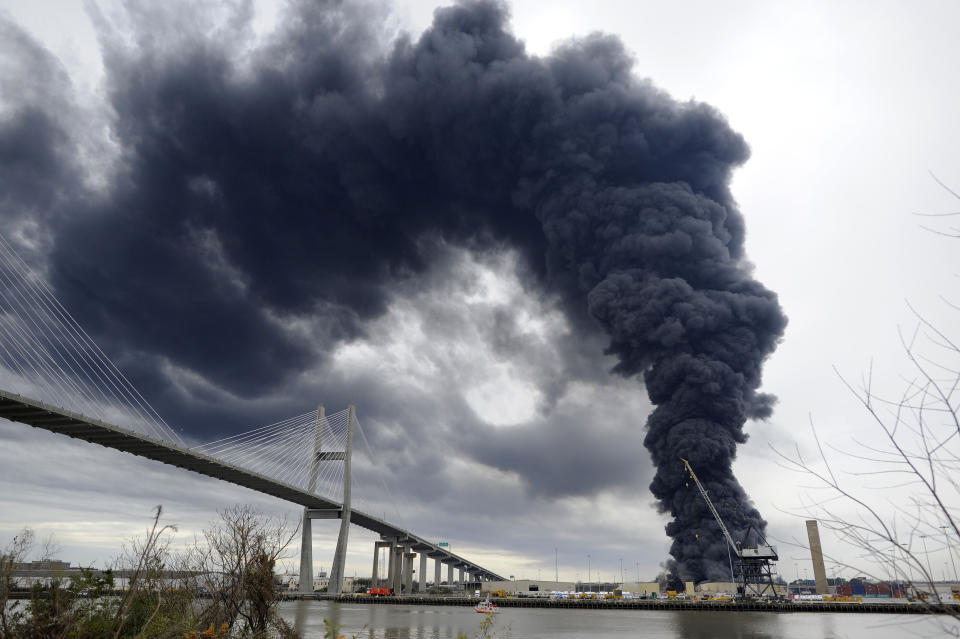 Firefighters battle a blaze in a warehouse at the Georgia Ports Authority Ocean Terminal, Saturday, Feb. 8, 2014, in Savannah, Ga. Burning rubber from the fire at the Port of Savannah sent up a towering column of black smoke that could be seen from miles away. The cause of the fire wasn't immediately known, but all port workers were accounted for and unharmed.(AP Photo/Stephen B. Morton)