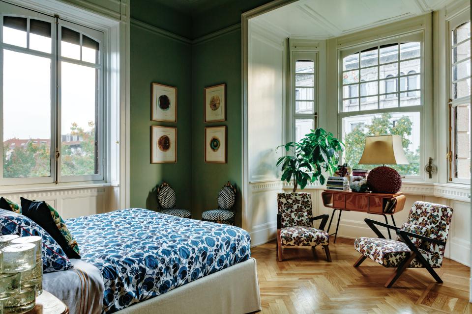 In the primary bedroom, two Fiftypop by Matì armchairs wearing La DoubleJ stretch cotton flank a vintage console. Four watercolors by Naida Tarakcija hang above 18th-century Italian boudoir chairs covered in a David Hicks fabric. The custom bed is dressed in La DoubleJ bedding