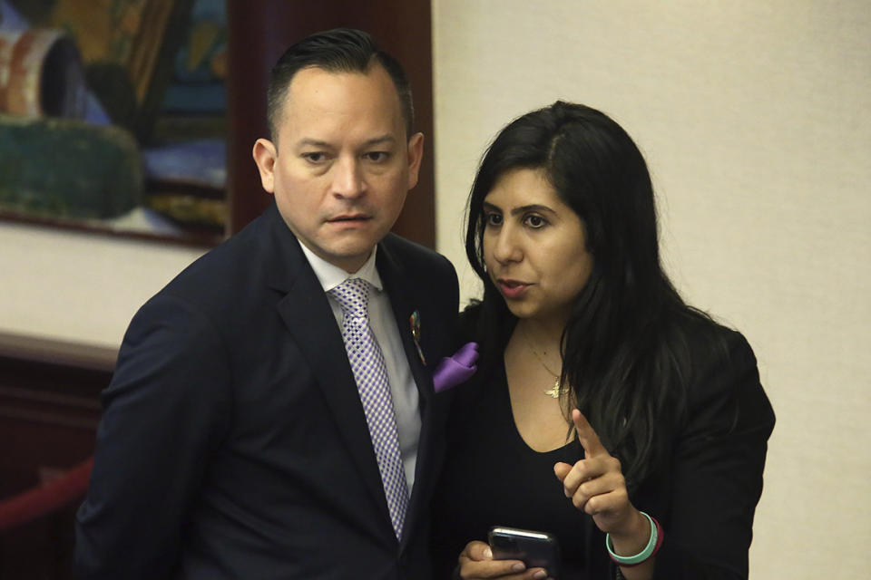 Rep. Anna Eskamani, D-Orlando, right, confers with Rep. Carlos Smith, D-Orlando, during the debate on the E-verify bill during session Wednesday, March 11, 2020 in Tallahassee, Fla. (AP Photo/Steve Cannon)