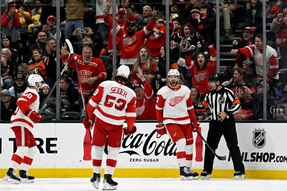 Detroit Red Wings center Michael Rasmussen, second from right, celebrates after his goal against the Anaheim Ducks with defenseman Moritz Seider (53) and center Joe Veleno, left, during the third period at Honda Center in Anaheim, California, on Sunday, Jan. 7, 2024.
