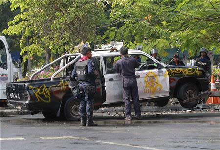 Police officers remove a damaged police pick-up truck near the Government House in Bangkok December 14, 2013. REUTERS/Chaiwat Subprasom