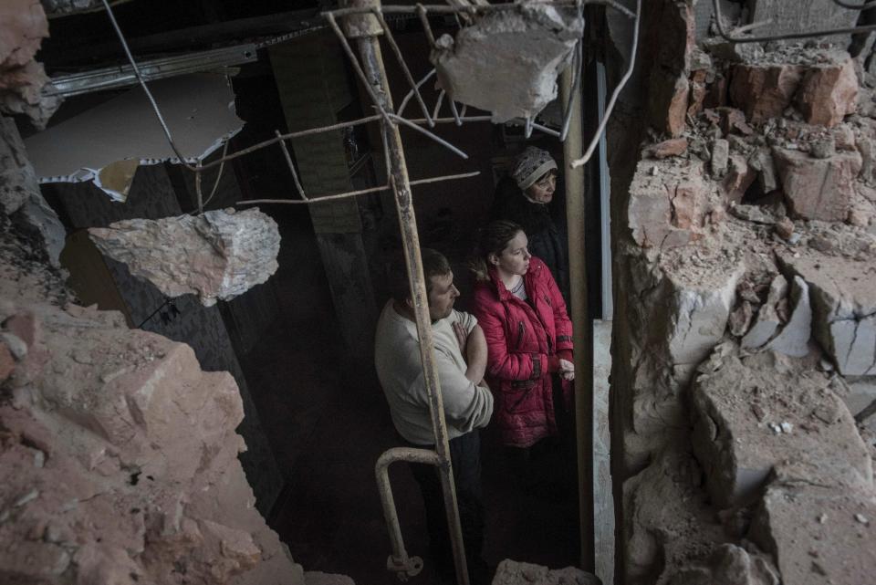 Roman and Olga Duzhikov look through the window of their flat damaged by shelling in Avdiivka, Ukraine, Saturday, Feb. 4, 2017. Fighting in eastern Ukraine sharply escalated this week. The Ukrainian command said Saturday that several soldiers were killed in the past day. (AP Photo/Evgeniy Maloletka)