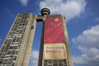 Workers hang on ropes to install a giant Chinese national flag on a skyscraper that is a symbolic gateway leading into the city from the airport, in Belgrade, Serbia, Saturday, May 4, 2024. Chinese leader Xi Jinping's visit to European ally Serbia on Tuesday falls on a symbolic date: the 25th anniversary of the bombing of the Chinese Embassy in Belgrade during NATO's air war over Kosovo. (AP Photo/Darko Vojinovic)