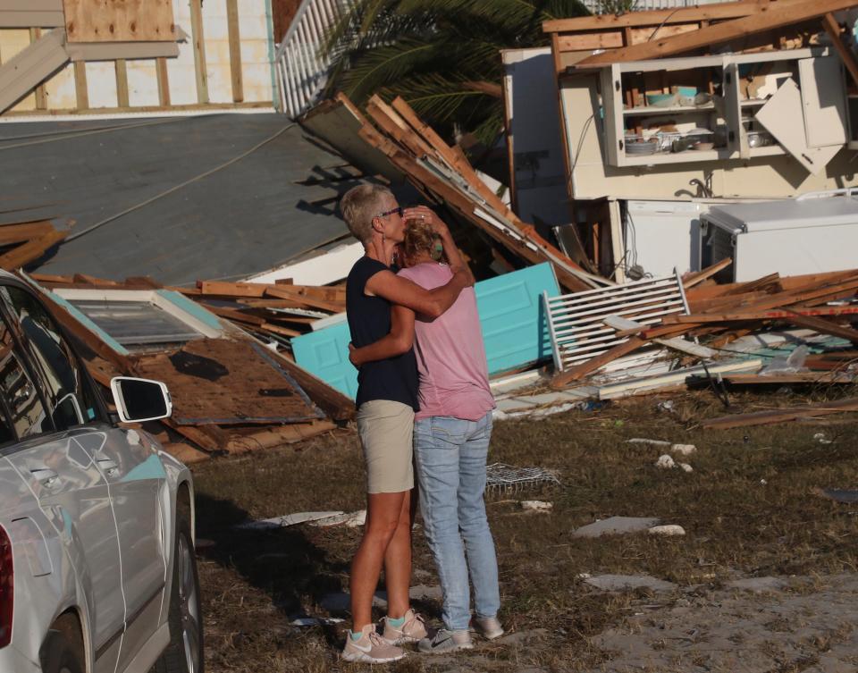 Becky Daniel hugs her wife Monica Barber as they drive up to see what is left of their Beacon Hill, Fla., home. It is next to Mexico City. It was ground zero for Hurricane Michael.