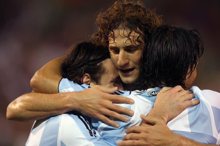 Coloccini, con la camiseta de la selección nacional, y el abrazo con Lionel Messi; cerca de los 40 años, el defensor le puso fin a su carrera