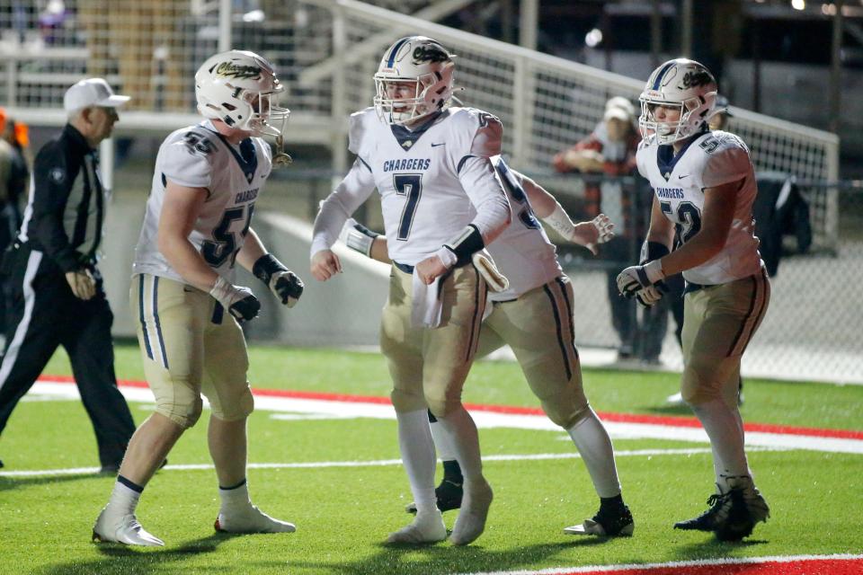 Heritage Hall's Andy Bass, center, celebrates with teammates Zavier Freeman, left, and Jack Harris after Bass ran for a touchdown Friday against Verdigris in Prague.