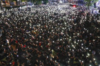 CORRECTS DATE Pro-democracy demonstrators shine their mobile phone lights during a march to the German Embassy in central Bangkok, Thailand, Sunday, Oct. 25, 2020. As lawmakers debated in a special session in Parliament that was called to address political tensions, student-led rallies were set to continue with a march through central Bangkok on Monday evening to the German Embassy, apparently to bring attention to the time King Maha Vajiralongkorn spends in Germany. (AP Photo/Gemunu Amarasinghe)