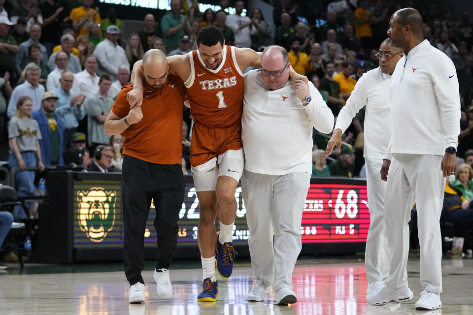 Texas's Dylan Disu (1) is helped off the court by trainers during the second half of an NCAA college basketball game against Baylor, Monday, March 4, 2024, in Waco, Texas. Baylor won 93-85. Disu did not return to the court. (AP Photo/Julio Cortez)