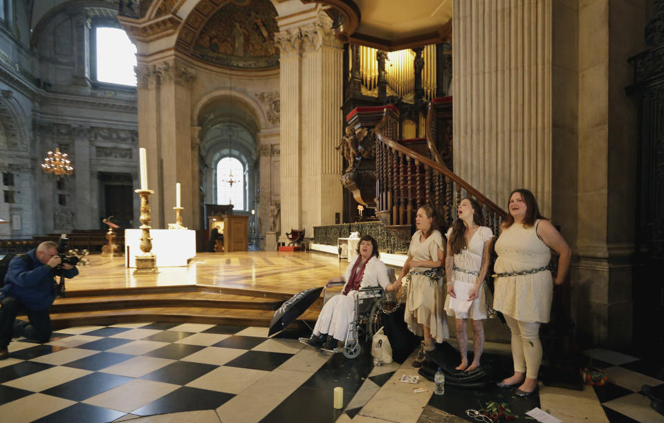 Four women activists of the Occupy movement protest chained to the pulpit inside St Paul's Cathedral as preparations for evensong take place in London, Sunday, Oct. 14, 2012. Several supporters of the anti-corporate Occupy movement chained themselves to the pulpit of St. Paul's Cathedral during a service on Sunday in an action marking the anniversary of its now-dismantled protest camp outside the London landmark. (AP Photo/Alastair Grant)