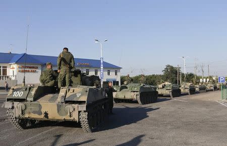 Russian military personnel sit atop armoured vehicles outside Kamensk-Shakhtinsky, Rostov Region, August 15, 2014. REUTERS/Maxim Shemetov