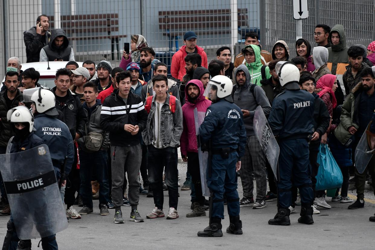 Greek anti-riot police patroling refugees from the Moria camp hoping to get a ferry to Athens