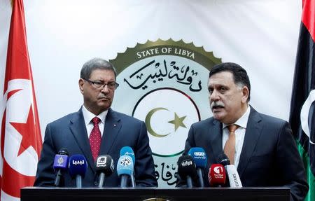 Tunisian Prime Minister Habib Essid (L) listens to Prime Minister of Libya's unity government Fayez Serraj (R) during a joint news conference in Tripoli, Libya, May 6, 2016. REUTERS/Ismail Zitouny