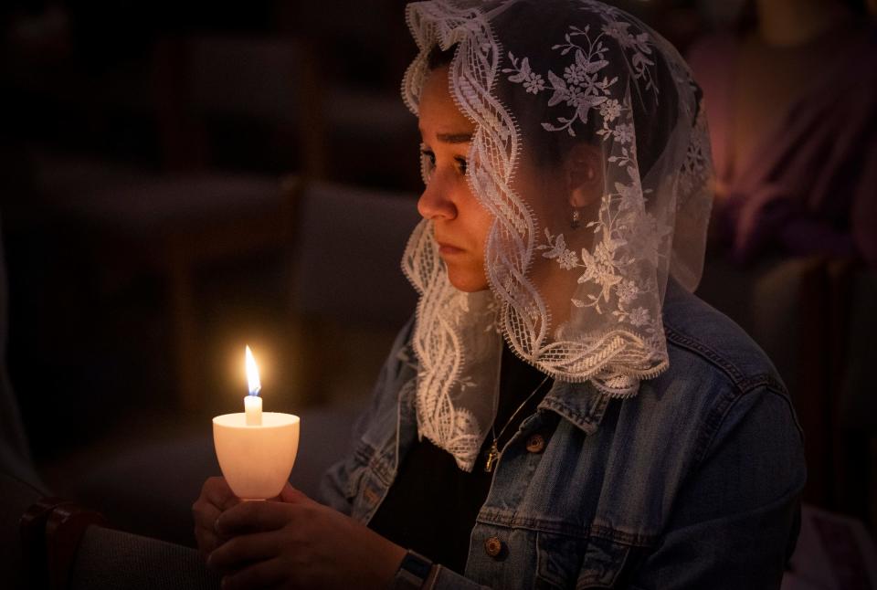 Caryn Dannah, of Detroit, a campus missionary at Detroit Catholic Campus Ministry, prays during Holy Thursday services on Thursday, April 6, 2023, in St. Joseph Hall at Our Lady of the Rosary Catholic Church in Detroit.
