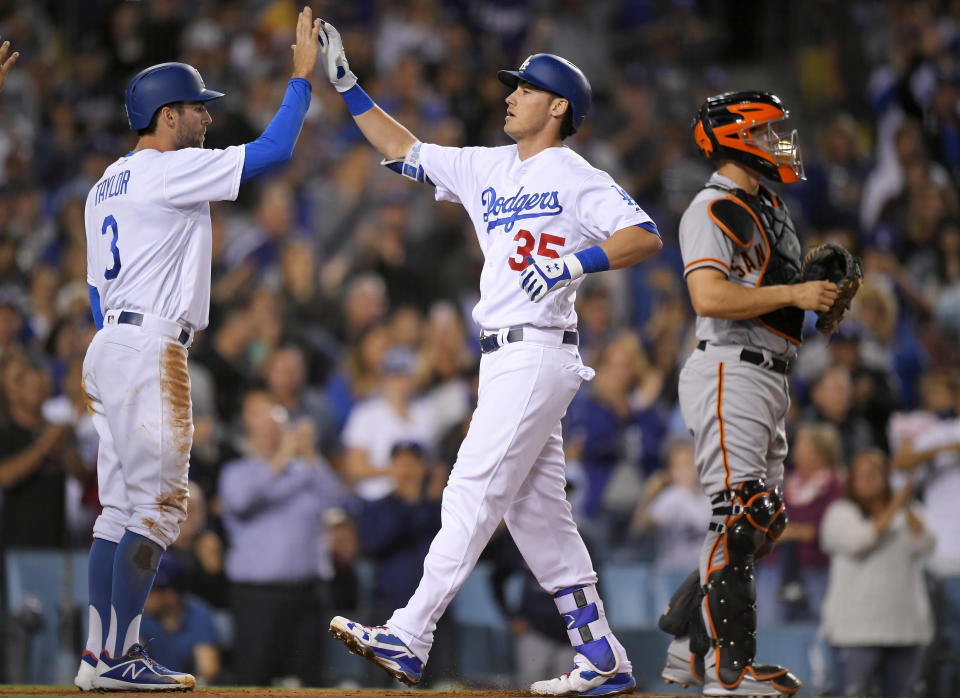 Dodgers' rookie Cody Bellinger congratulated by Chris Taylor after hitting a three-run home run in the Dodgers division-clinching win. (AP)