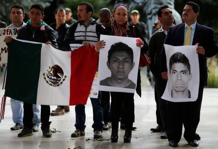 Demonstrators hold Mexican flag and portraits of missing students as they take part in a protest in support of the 43 missing students of the Ayotzinapa teachers' training college Raul Isidro Burgos, outside the Mexican Embassy in Bogota November 7, 2014. REUTERS/John Vizcaino