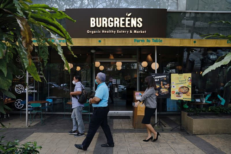 People walk past an outlet of Burgreens, a plant-based eatry chain, in Serpong, South Tangerang