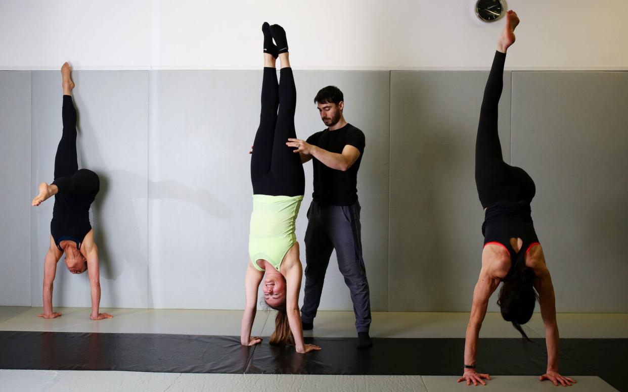 Agnes Arnold-Foster is supported by handstand class teacher Sammy Dinneen at Urban Kings Gym in Kings Cross - Clara Molden/The Telegraph