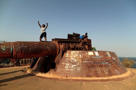Woman poses for pictures while standing on an old French gun emplacement at Goree Island off the coast of Dakar