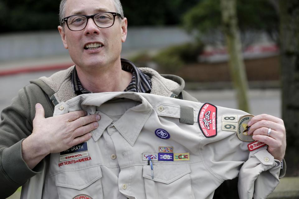 Geoff McGrath holds his Boy Scout scoutmaster uniform shirt for the Seattle troop he led, Tuesday, April 1, 2014, in Bellevue, Wash. The Boys Scouts of America has removed McGrath, an openly gay troop leader, after saying he made an issue out of his sexual orientation. The BSA told McGrath in a letter Monday that “it has no choice but to revoke your registration” after he told news media he was gay in connection with a news story. McGrath, who earned the rank of Eagle Scout, has been leading Seattle Troop 98 since its application was approved last fall. (AP Photo/Elaine Thompson)