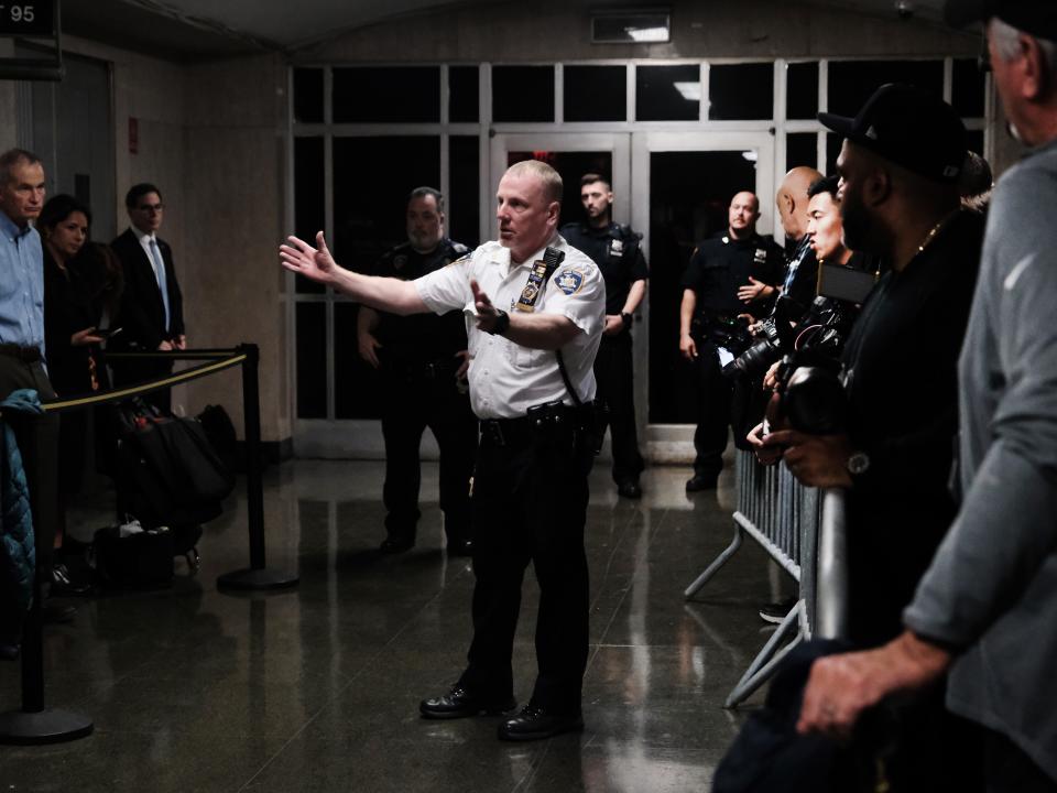 A court officer speaks to the media outside of the court room at New York State Supreme Court during the start of jury selection in a case against the Trump Organization