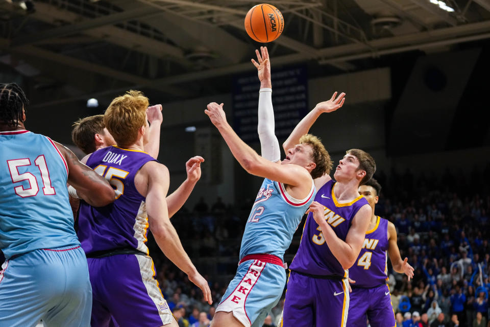 Drake's Tucker DeVries shoots over Northern Iowa defenders during Wednesday's game at the Knapp Center. Drake defeated the Panthers in double overtime, 88-81.