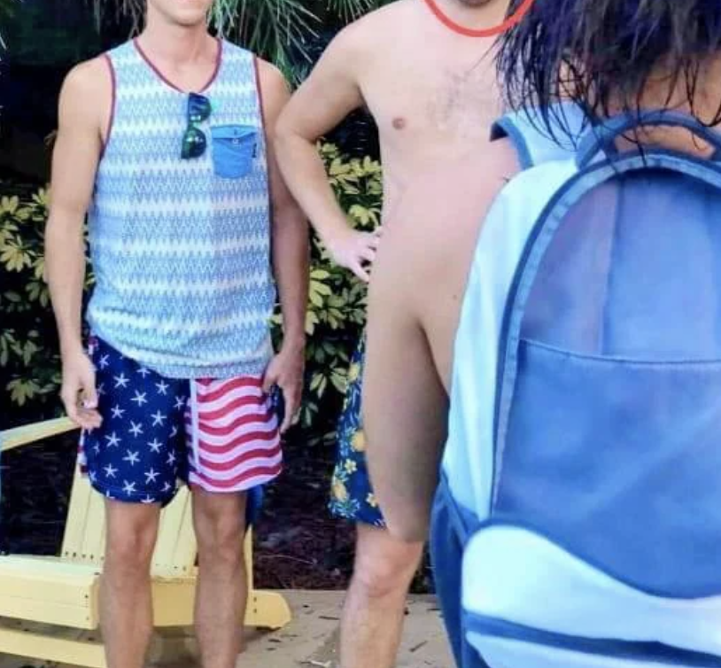 Two unidentified men in summer attire stand outside. One wears a zigzag tank top with American flag shorts; the other is shirtless with blue floral shorts