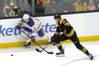 Boston Bruins center Charlie Coyle (13) and Buffalo Sabres center Peyton Krebs (19) compete for the puck during the third period of an NHL hockey game, Saturday, Jan. 1, 2022, in Boston. (AP Photo/Mary Schwalm)