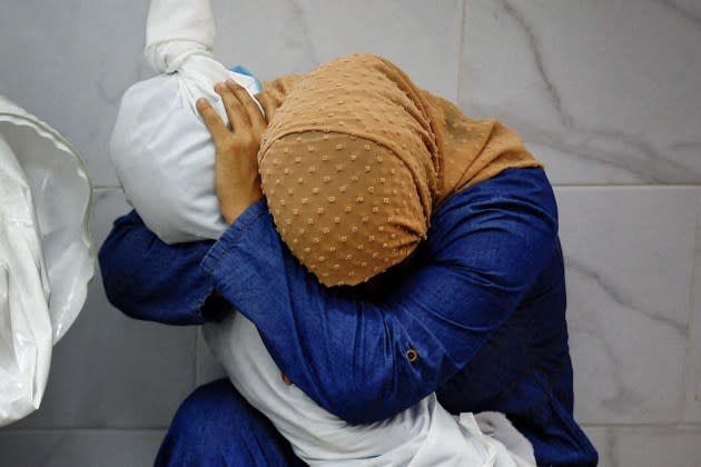 Palestinian woman Inas Abu Maamar, 36, embraces the body of her 5-year-old niece Saly, who was killed in an Israeli strike, at Nasser hospital in Khan Younis in the southern Gaza Strip, October 17, 2023.  - Credit: Mohammed Salem/REUTERS/Redux