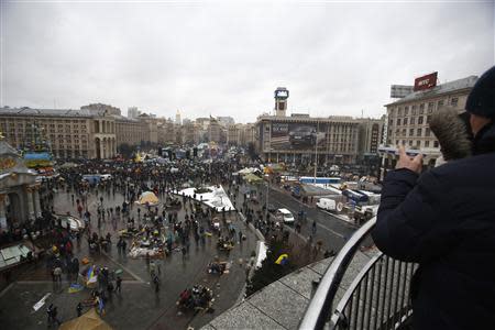 A couple looks on as protesters gather at Independence Square in Kiev December 7, 2013. REUTERS/Stoyan Nenov