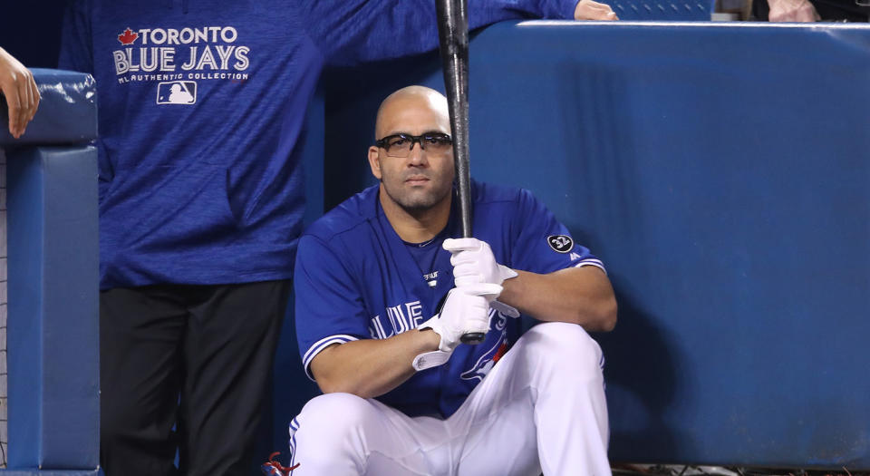 Kendrys Morales #8 of the Toronto Blue Jays holds his bat as he looks out from the top step of the dugout during a game against the Texas Rangers. (Tom Szczerbowski/Getty Images)