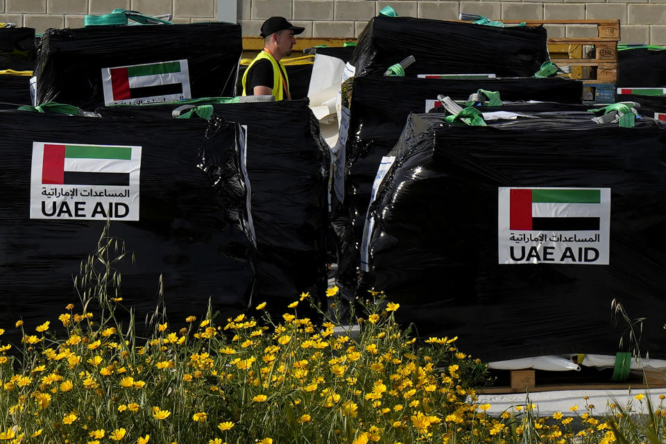 A member of the World Central Kitchen walks by the humanitarian aid loaded onto pallets for transport to the port of Larnaca from where it's going to be shipped to Gaza, at a warehouse near Larnaca, Cyprus, on Wednesday, March 13, 2024. Cyprus' foreign minister Constantinos Kombos said that a second vessel being loaded with aid for Gaza is currently docked at Larnaca port and is preparing to depart. (AP Photo/Petros Karadjias)