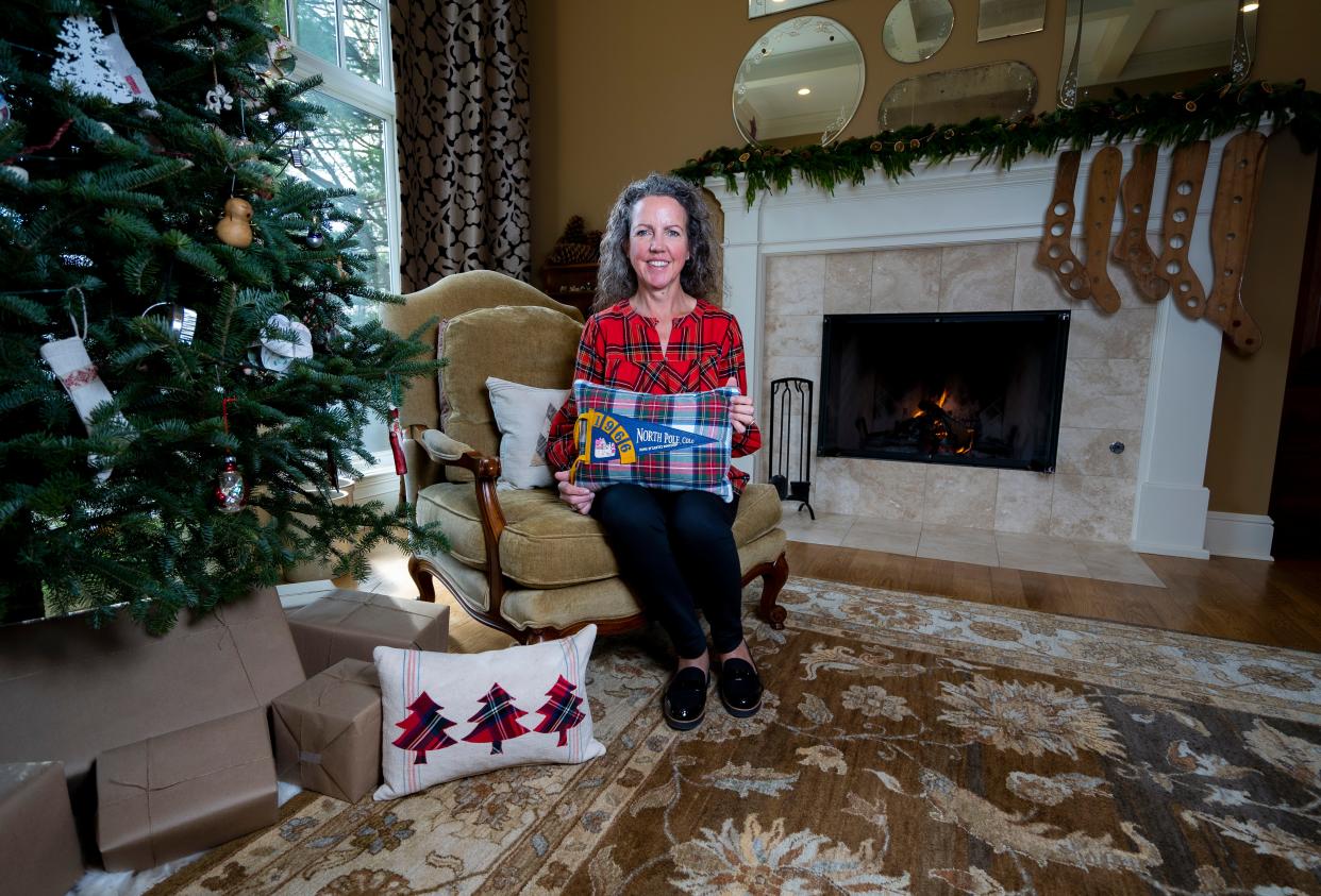 Julie Hunt poses for a portrait with the pillows she made from pennants on Saturday November 11, 2023 in Hartland, Wis. Julie Hunt makes decorative pillows out of a wide variety of fabrics, including varsity letters, and her pieces will be featured on this year's Monches Artisans Holiday Open House Tour.