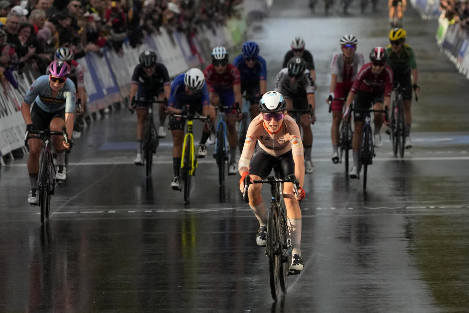 Annemiek van Vleuten of Netherlands, right front, races past the finish line to win the elite women's road race at the world road cycling championships in Wollongong, Australia, Saturday, Sept. 24, 2022. (AP Photo/Rick Rycroft)