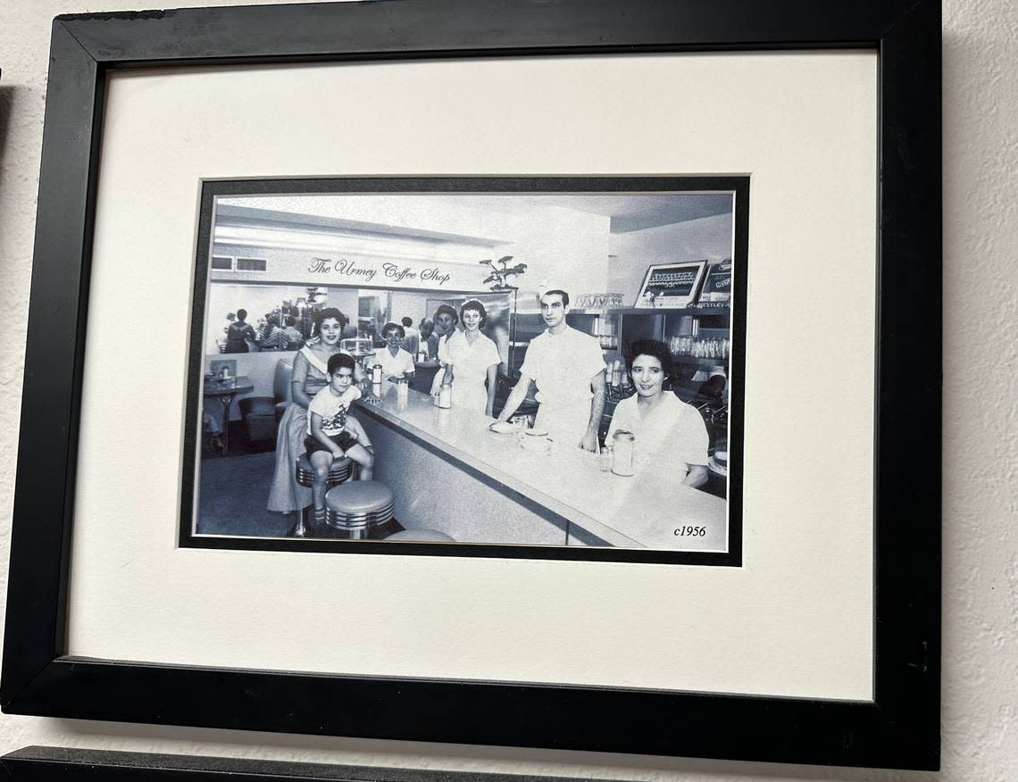 Nick Poulos, then about 5 or 6 in this circa 1956 family photo, is seated on a stool inside The Urmey Coffee Shop in downtown Miami, alongside his parents John and Lula. John Poulos ran the eatery inside the 1917 Urmey Hotel at 34 Southeast Second St. His father James owned the nearby Paramount restaurant. This photo hangs inside Lots of Lox, the deli in the Coral Reef Shopping Center in Palmetto Bay, that the family owns. Howard Cohen/hcohen@miamiherald.com