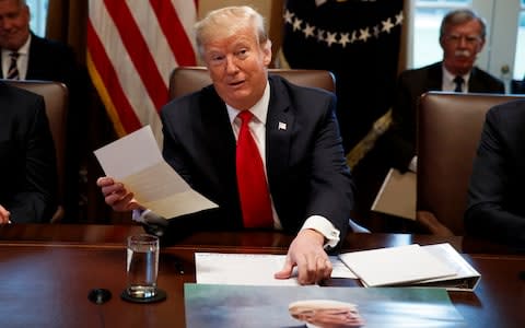 President Trump holds up a letter he says he received from Kim Jong-un - Credit: Evan Vucci/AP