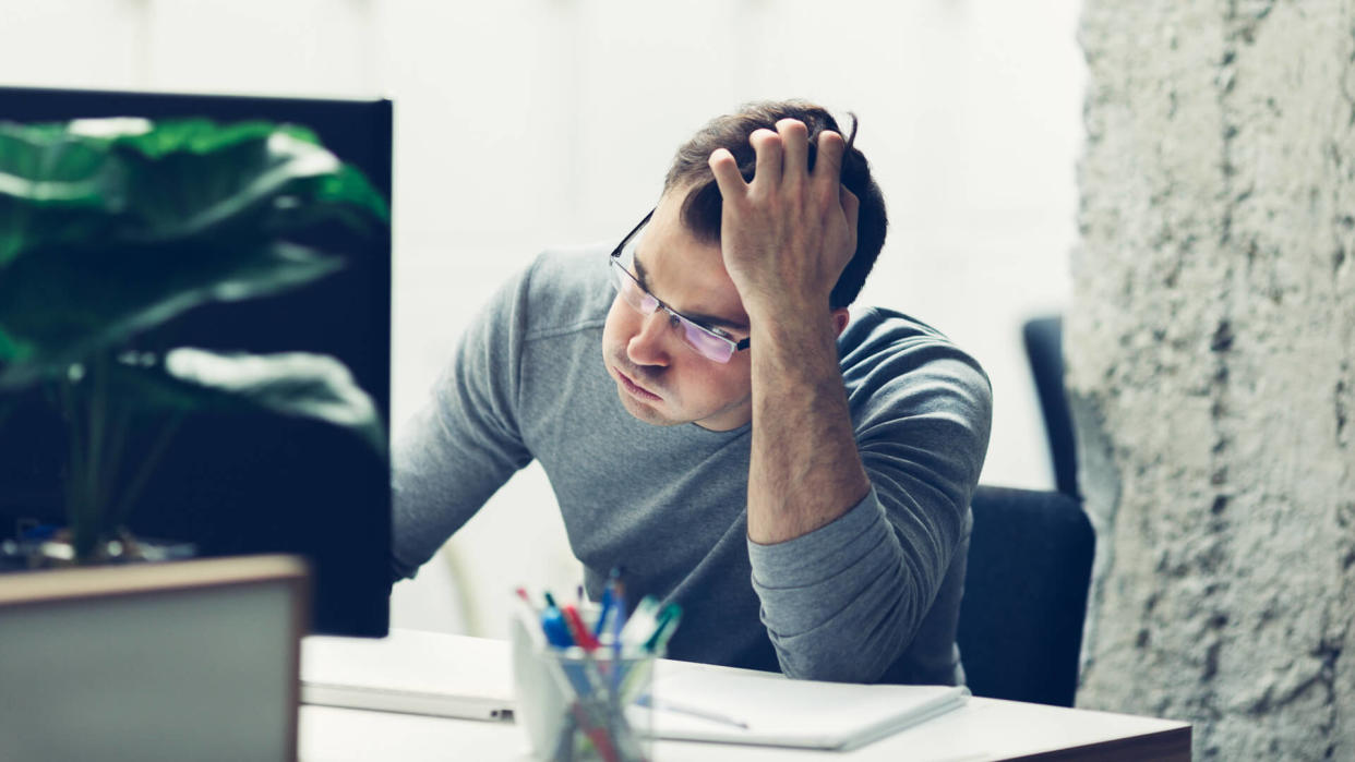 Worried businessman working in office.