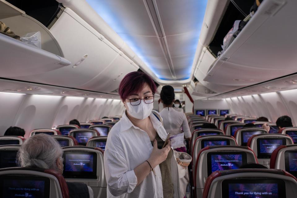 Un pasajero usa una máscara quirúrgica dentro de un avión en el aeropuerto internacional de Hong Kong. A medida que aumenta el número de víctimas del nuevo Coronavirus, más países cancelan vuelos dentro y fuera de la región. (Foto de Ivan Abreu / SOPA Images / LightRocket a través de Getty Images)