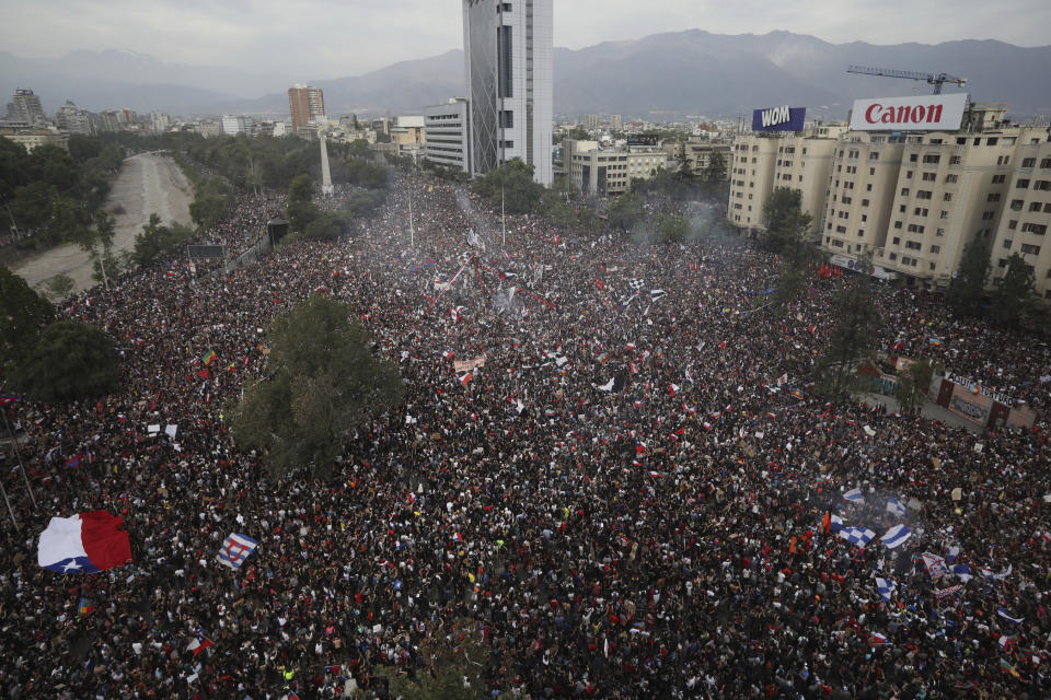 In this Oct. 25, 2019 photo, people gather during an anti-government protest in Santiago, Chile. At least 20 people have died in the turmoil that has swept the South American nation. The unrest began as a protest over a 4-cent increase in subway fares and soon morphed into a larger movement over growing inequality in one of Latin America's wealthiest countries. (AP Photo/Rodrigo Abd)