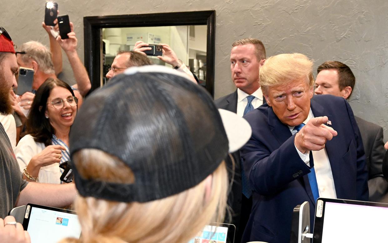 In this April photo, former President Donald Trump points at a menu item while stopping by Downtown House of Pizza in Fort Myers after a speech to Lee County Republicans.