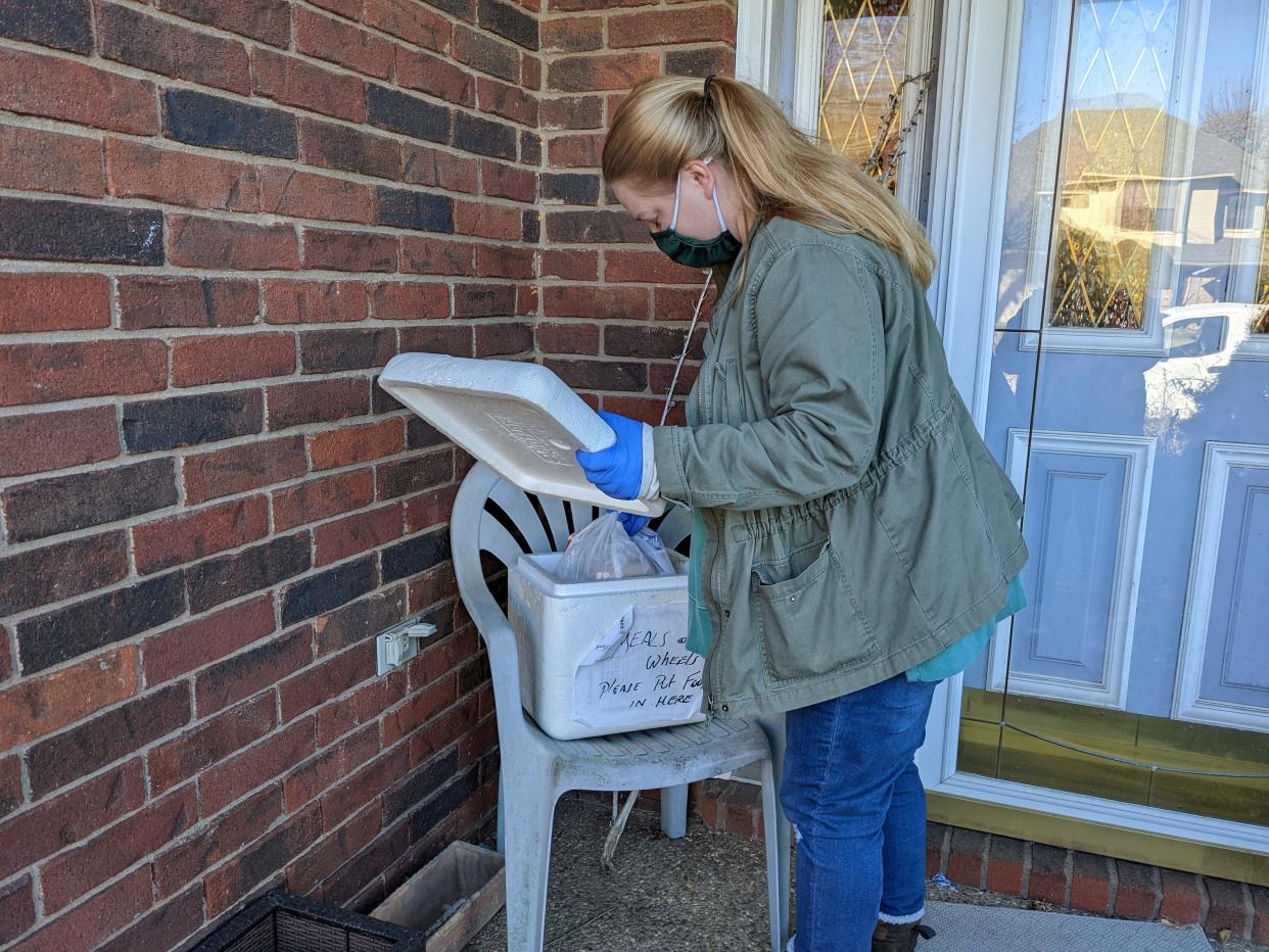 Allie Hicks, a driver with Meals on Wheels in Sebastian County, delivers food to a home.