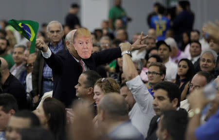 FILE PHOTO: A supporter of Federal deputy Jair Bolsonaro wears a mask of U.S. President Donald Trump before the national convention of the Social Liberal Party (PSL) where he is to be formalised as a candidate for the Presidency of the Republic, in Rio de Janeiro, Brazil July 22, 2018. REUTERS/Ricardo Moraes/File photo