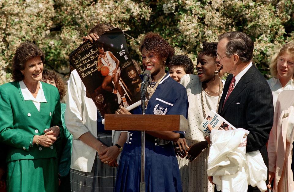 Lady Vol Bridgette Gordon presents President George Bush with a poster during a celebration of Tennessee's NCAA national championship on April 20, 1989 at the White House. At left is Coach Pat Summitt.