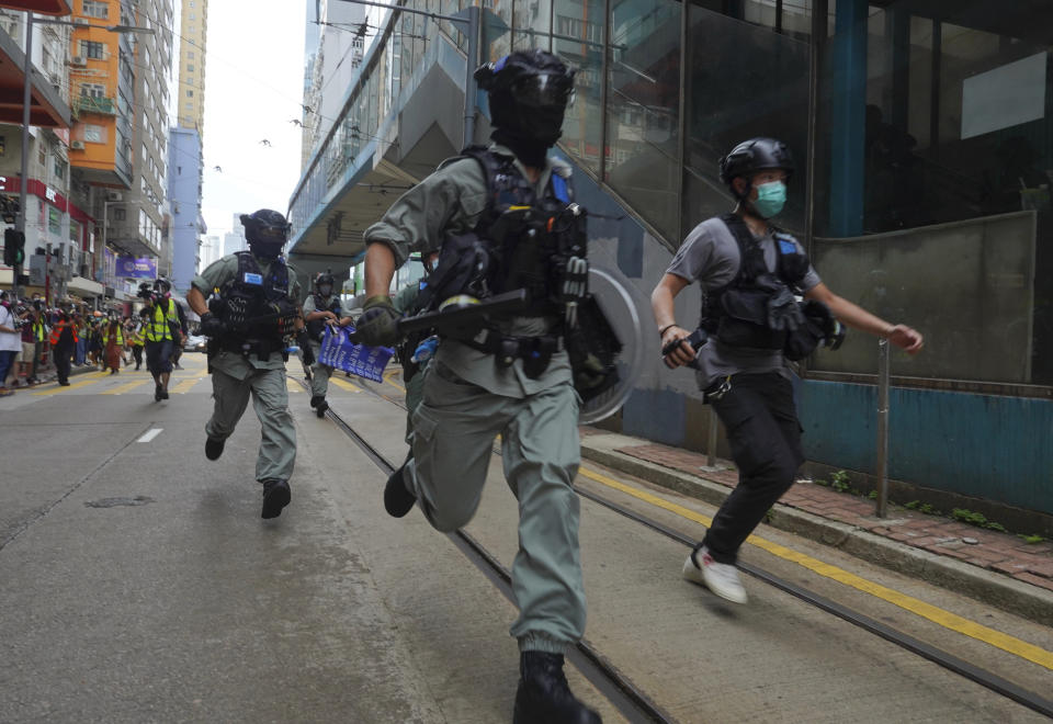 Police chase protesters during the annual handover march in Hong Kong, Wednesday, July. 1, 2020. Hong Kong marked the 23rd anniversary of its handover to China in 1997, and just one day after China enacted a national security law that cracks down on protests in the territory. Hong Kong police said on Facebook they had arrested over 30 people on various charges, from unlawful assembly to the violation of a national security law on the first day of the law. (AP Photo/Vincent Yu)