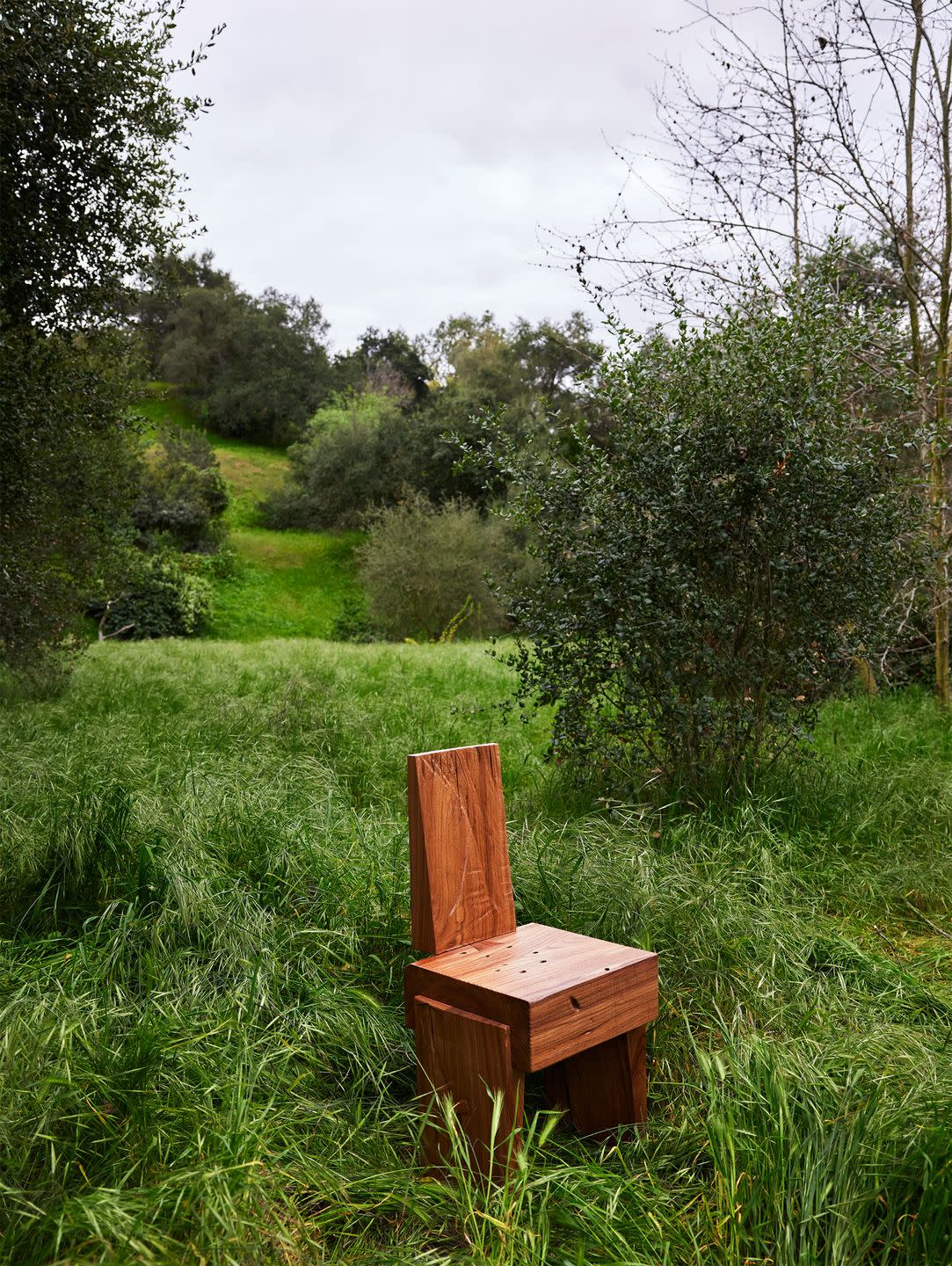 a wooden chair in a grassy area