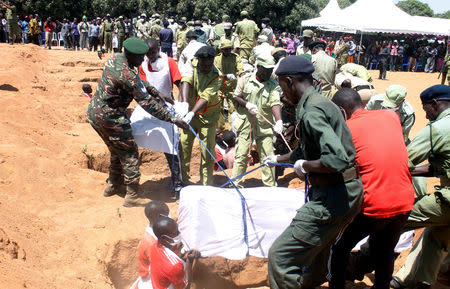 Tanzanian security agents and volunteers bury the coffins of containing the bodies of passengers retrieved after MV Nyerere ferry overturned off the shores of Ukara Island in Lake Victoria, Tanzania September 23, 2018. REUTERS/Stringer