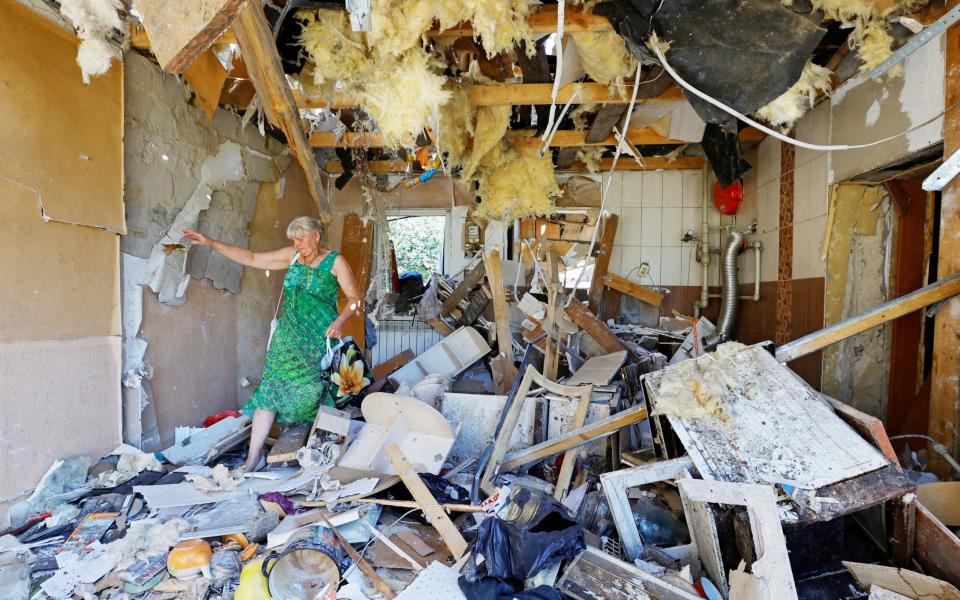 Lyubov Tolchina, 63, walks through the house of her son, who was killed the day before by shelling in Donetsk