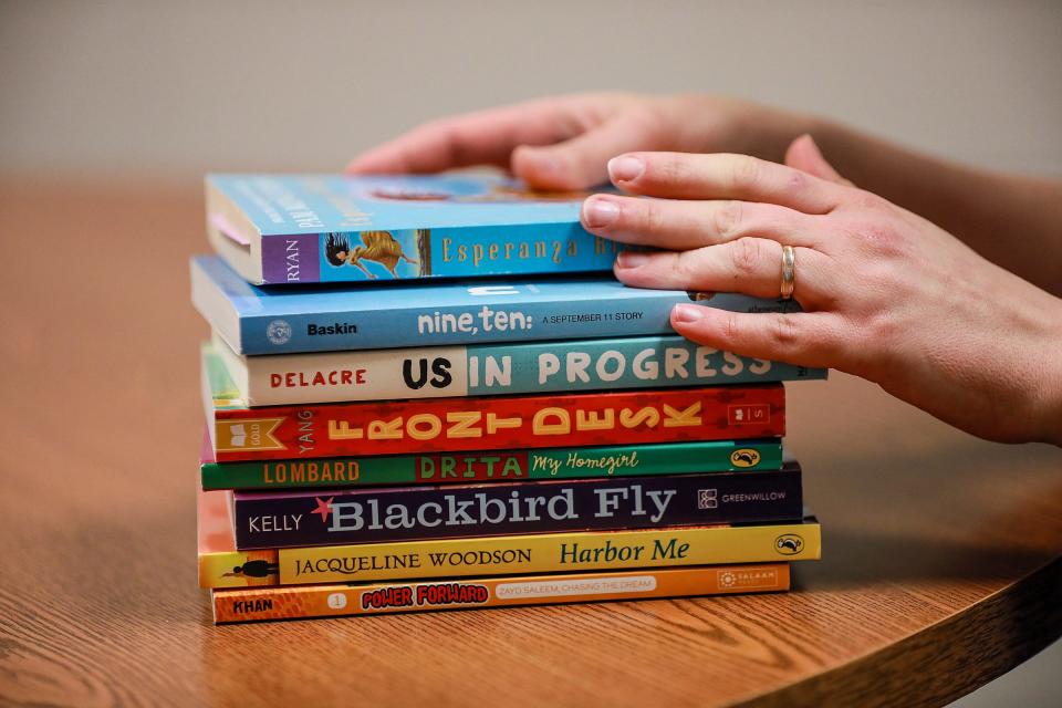 Maryna Hedeen, 35, of Monroe, teaches English Learning at Brownstown Middle School and places her hands over books she has collected for her students to read on Feb. 10, 2022.