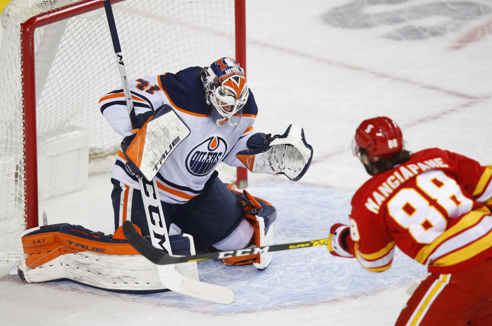 Calgary Flames' Andrew Mangiapane takes a shot on Edmonton Oilers goalie Mike Smith during the first period of an NHL hockey game, Friday, Feb. 19, 2021 in Calgary, Alberta. (Todd Korol/The Canadian Press via AP)