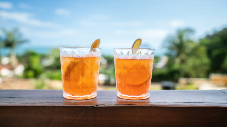Two orange cocktails on ledge