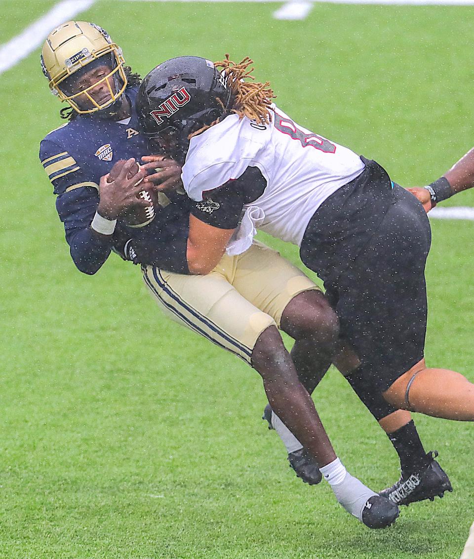University of Akron quarterback Tahj Bullock is sacked by NIU defensive tackle Devonte O’Malley during the second quarter Saturday in Akron.